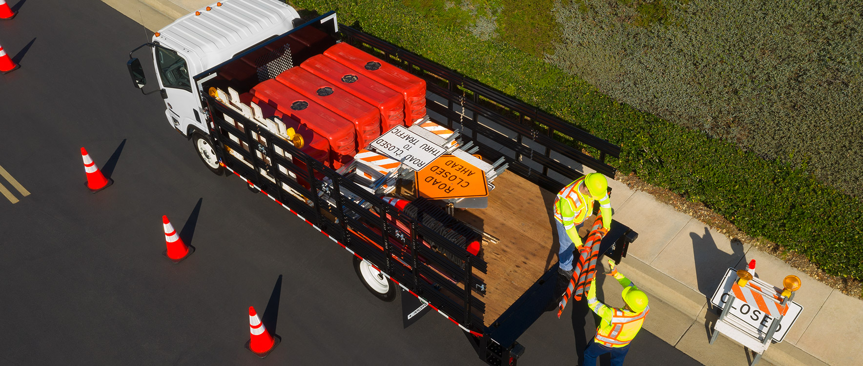 Public works employees using Platform/Dump Prostake to setup road signs for construction