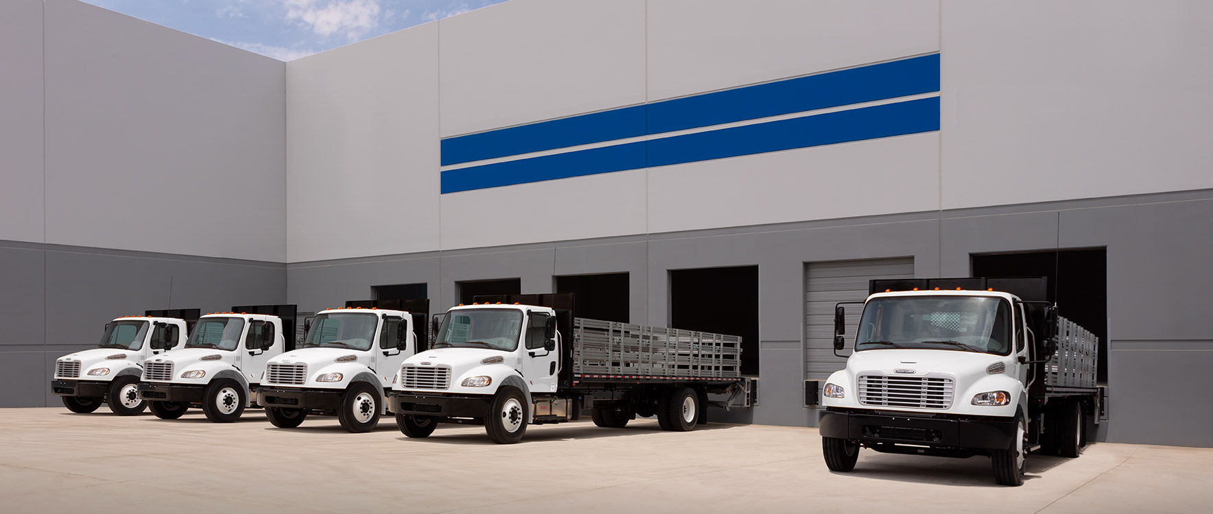 A fleet of Platform/Dump ProStake trucks at a loading dock